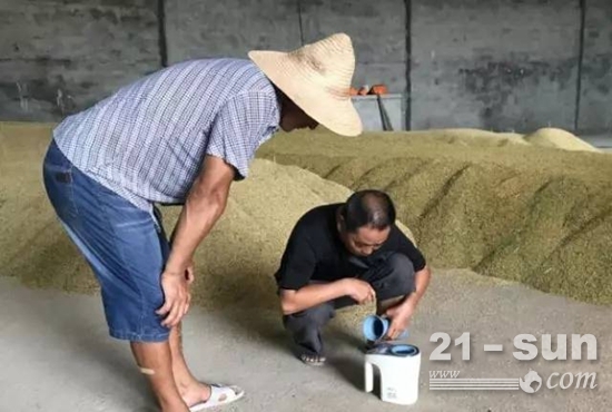 臧迎春检测农民送过来的稻谷水分，发现今年早稻的含水率普遍偏高