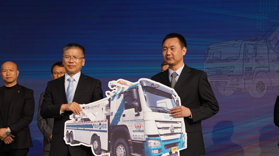 孙小军先生（左）将徐工大吨位清障车交付于廖广宇先生（右）