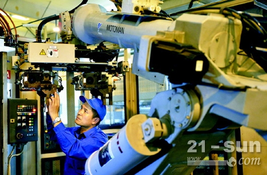 王树军正在对一台机器人进行改造以适应新产品的加工生产